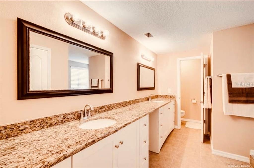 6850 Spring Rain Drive Orlando, FL 32819 - Photo 17 of 35 a bathroom with a granite countertop double vanity sink and a large mirror