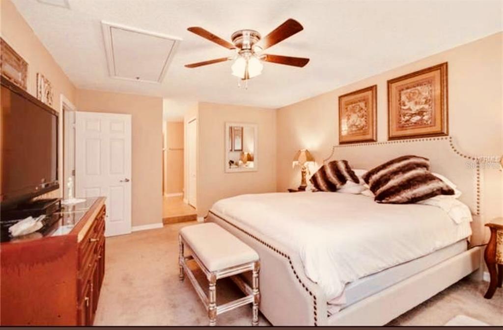 6850 Spring Rain Drive Orlando, FL 32819 - Photo 19 of 35 a bedroom with a bed and a flat screen tv