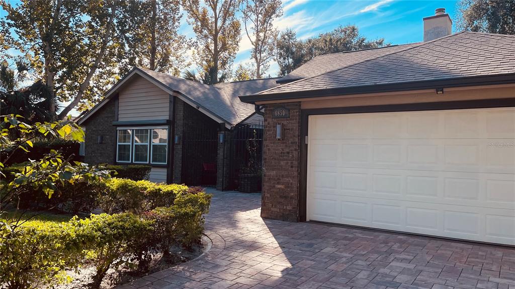 6850 Spring Rain Drive Orlando, FL 32819 - Photo 2 of 35 a front view of a house with a yard