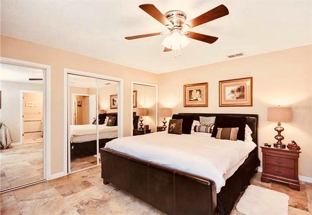 6850 Spring Rain Drive Orlando, FL 32819 - Photo 22 of 35 a large bedroom with a large bed and a chandelier