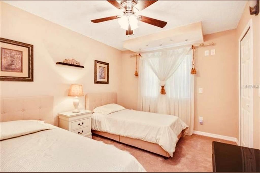 6850 Spring Rain Drive Orlando, FL 32819 - Photo 23 of 35 a bedroom with a bed and a chandelier