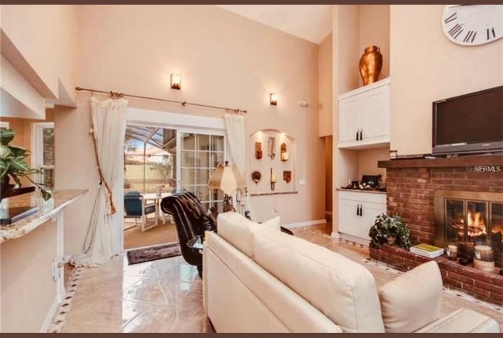 6850 Spring Rain Drive Orlando, FL 32819 - Photo 7 of 35 a living room with furniture a flat screen tv and a fireplace