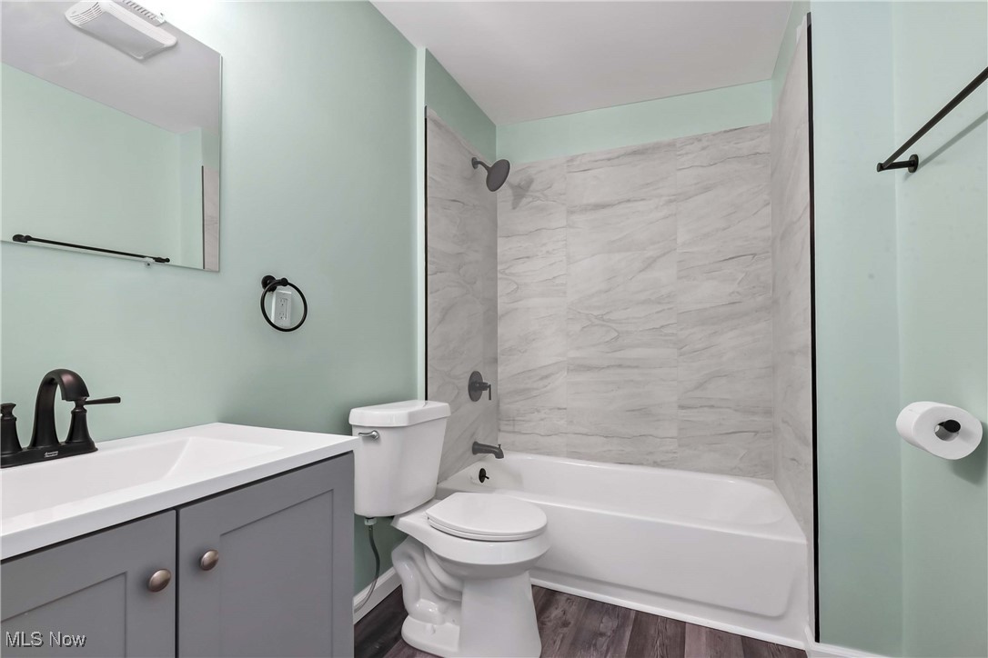 2022 Rohde Street Sandusky, OH 44870 - Photo 9 of 29 Full bathroom featuring tiled shower / bath, toilet, vanity, and LVT flooring