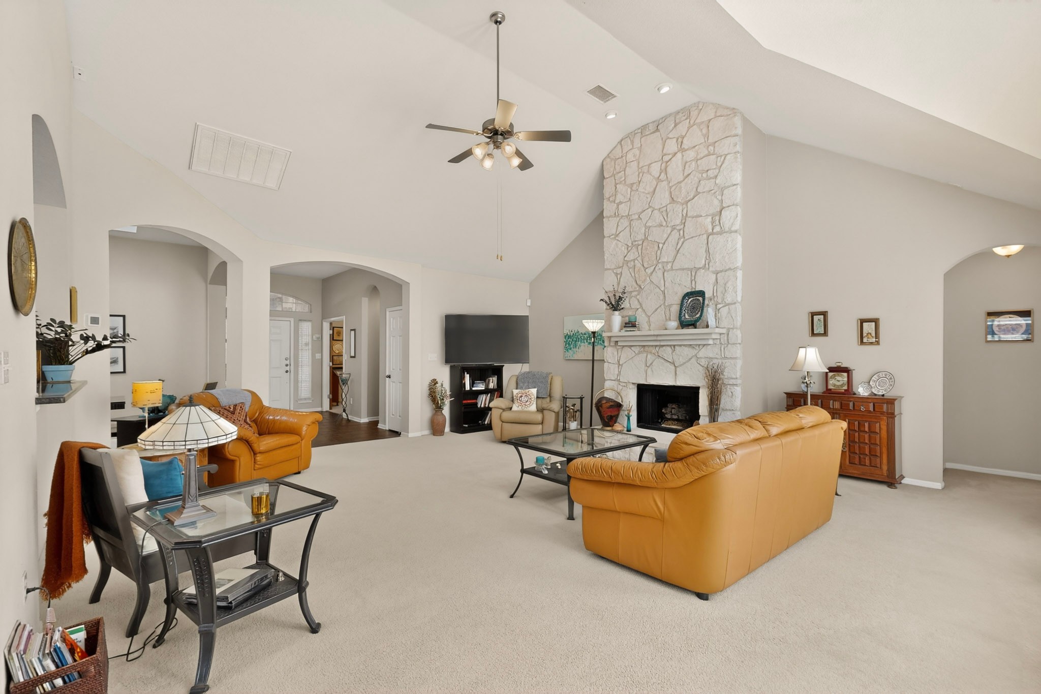 905 Victoria Ridge Drive Pflugerville, TX 78660 - Photo 4 of 32 Vast living area with a vaulted ceiling and a stately stone fireplace creates a welcoming atmosphere.