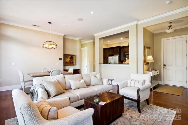 a living room with furniture kitchen view and a chandelier