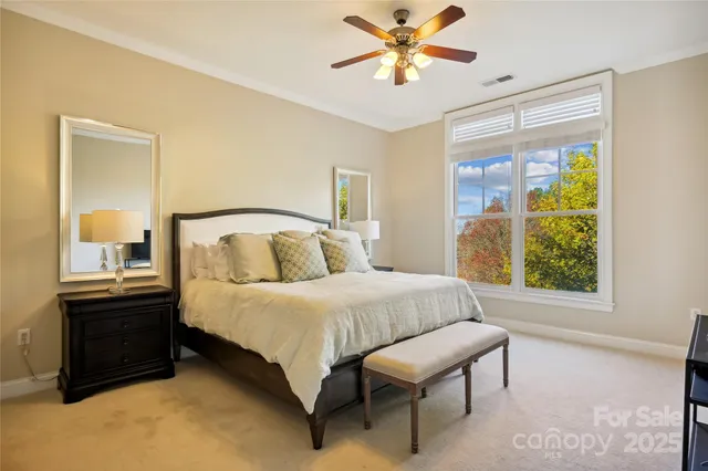 a bedroom with a bed chandelier and a window