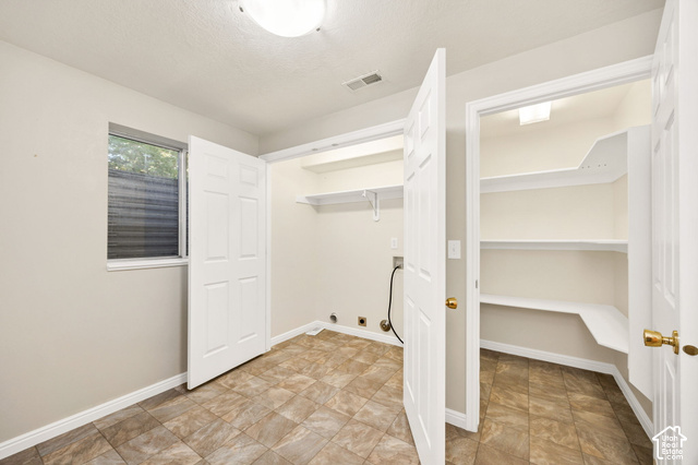 1143 East Mountain Road Logan, UT 84321 - Photo 34 of 64 Laundry area with tiled flooring, built-in shelving, window with blinds, and additional storage closet with shelving