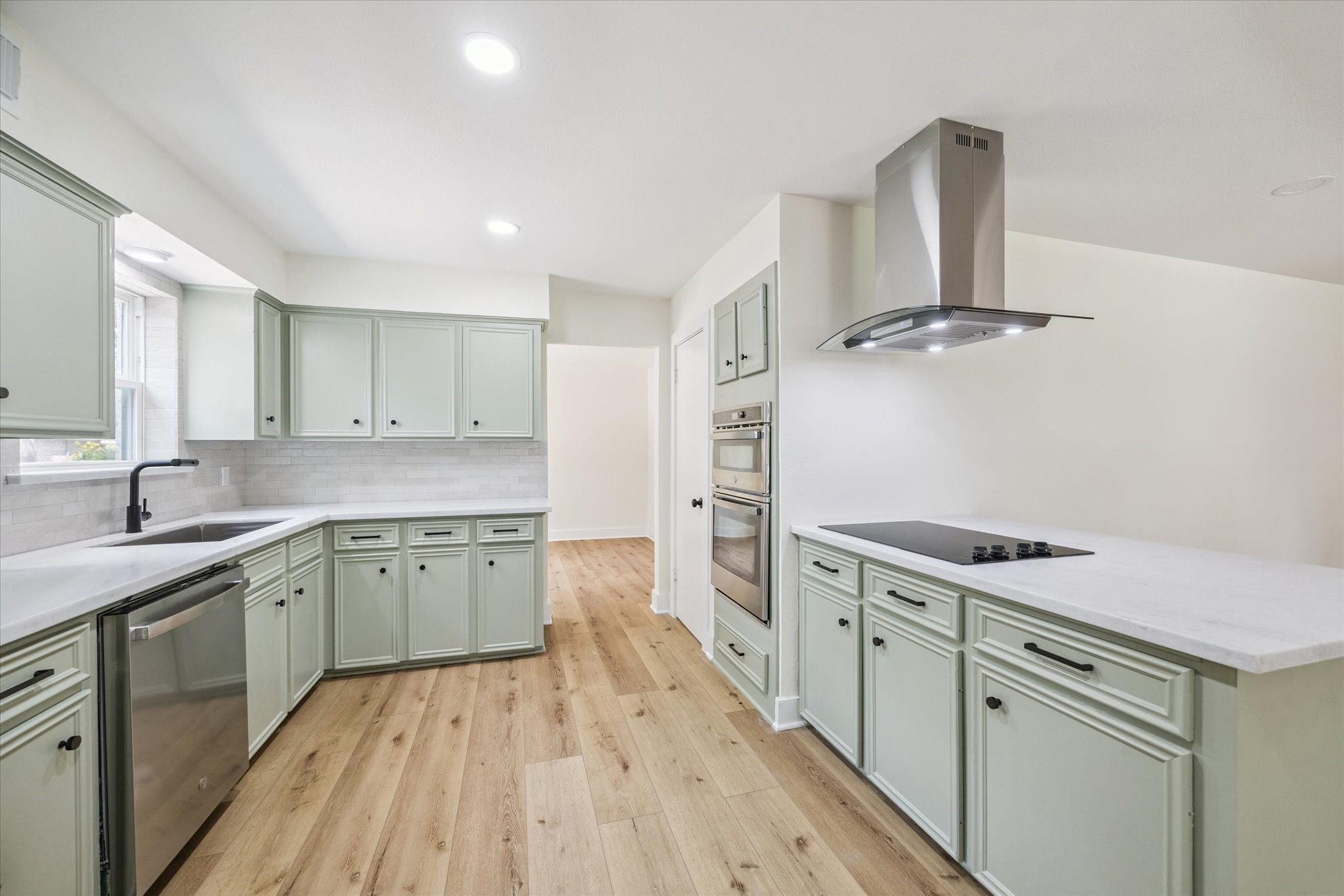2723 Bernadette Lane Houston, TX 77043 - Photo 12 of 32 a kitchen with a stove a sink and wooden floor