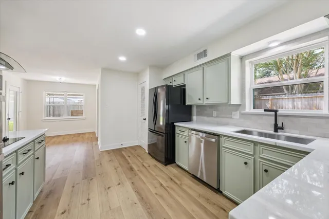 a kitchen with stainless steel appliances granite countertop a sink stove and refrigerator