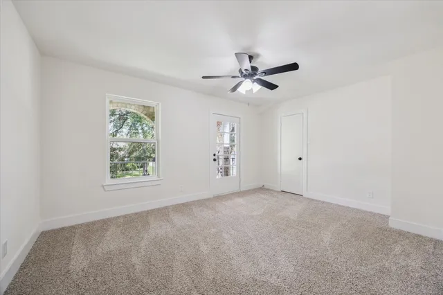 an empty room with a window and a fan