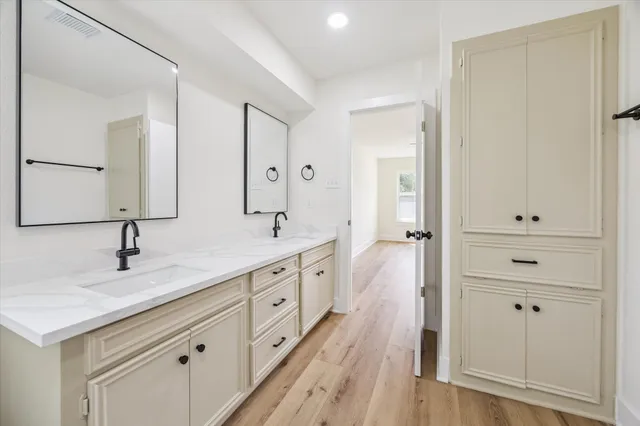 a spacious bathroom with a double vanity sink a mirror and shower