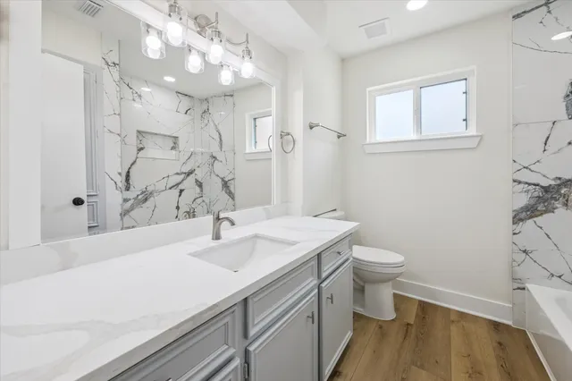 a bathroom with a sink a toilet and a mirror