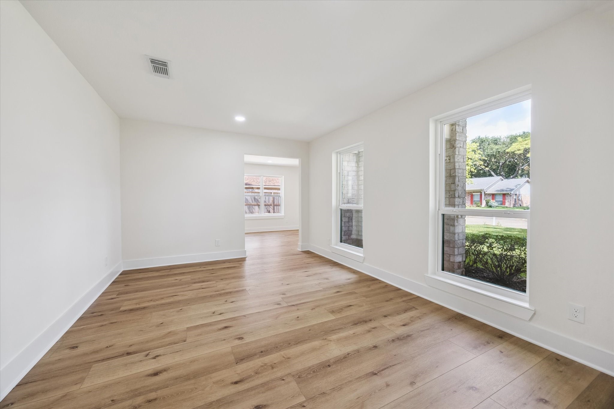 2723 Bernadette Lane Houston, TX 77043 - Photo 7 of 32 an empty room with wooden floor and windows