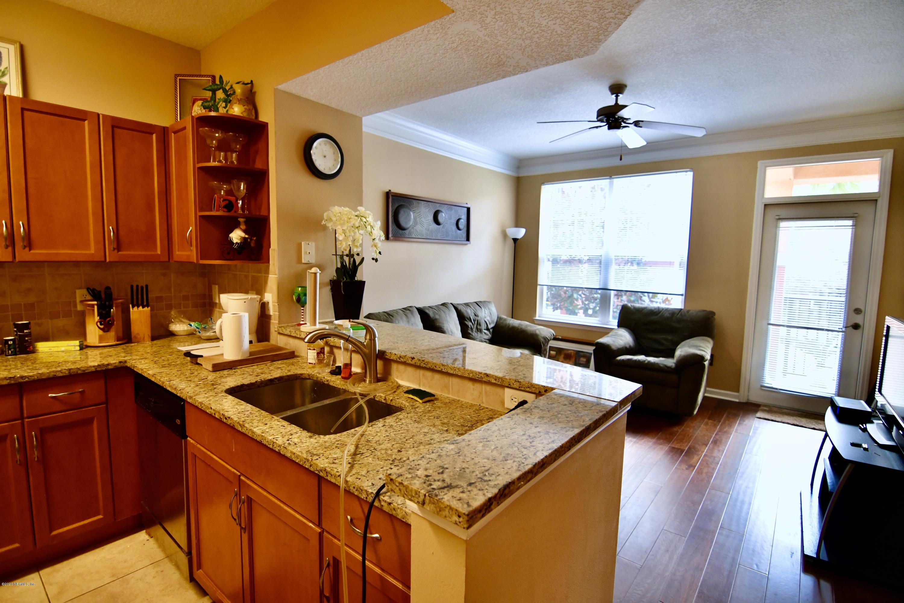 a kitchen with stainless steel appliances granite countertop a sink a stove and wooden floor