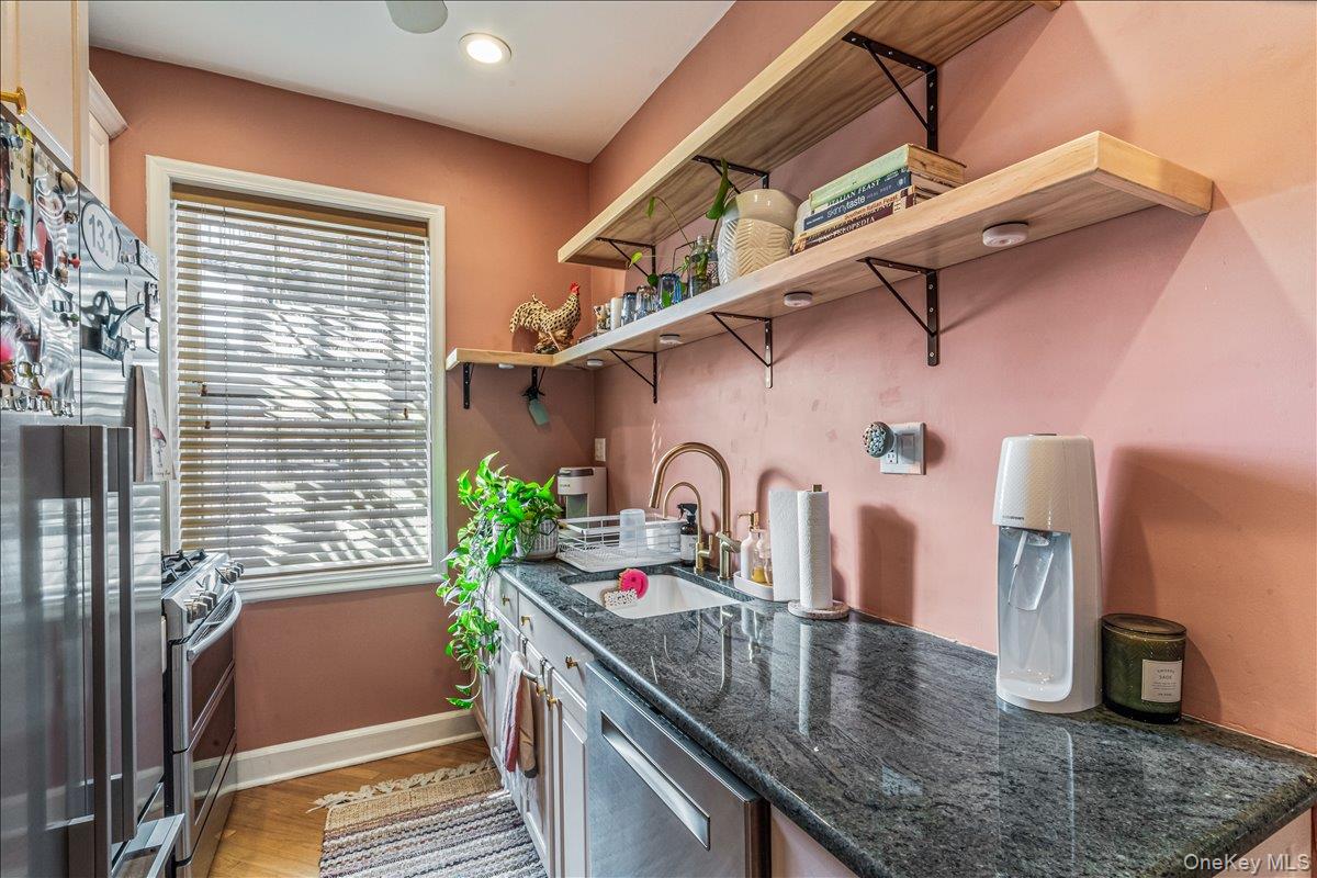 38-30 Douglaston Parkway, Unit G2 Queens, NY 11363 - Photo 13 of 19 a kitchen with stainless steel appliances granite countertop a sink a counter space and a window