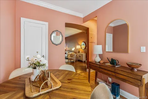 a living room with furniture flowerpot and wooden floor