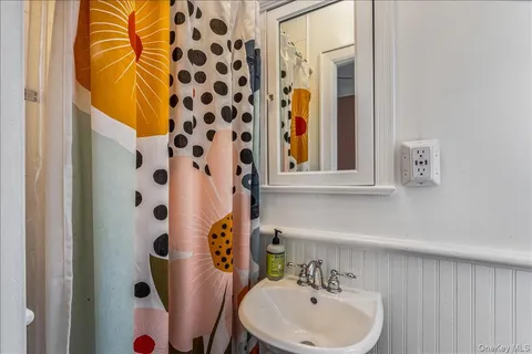 a bathroom with a sink and mirror with toilet