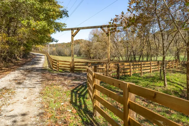 a view of a yard with wooden fence