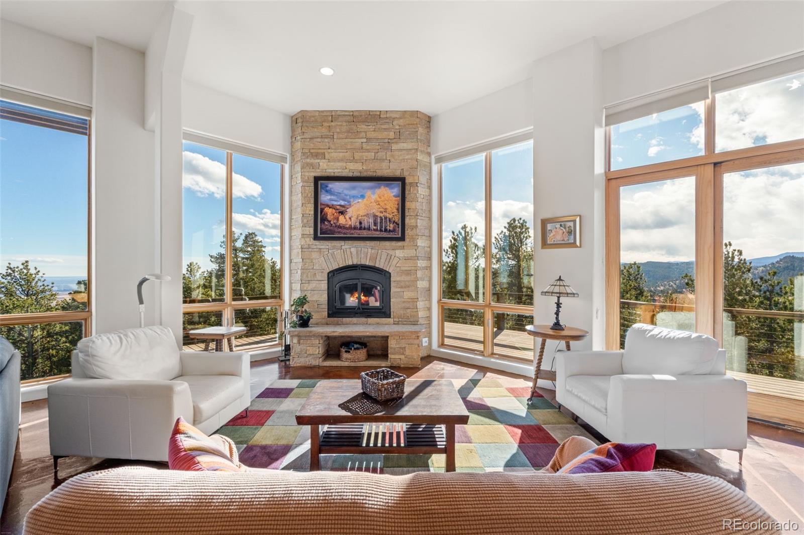 27659 Misty Road Golden, CO 80403 - Photo 12 of 50 a living room with furniture a flat screen tv and a fireplace