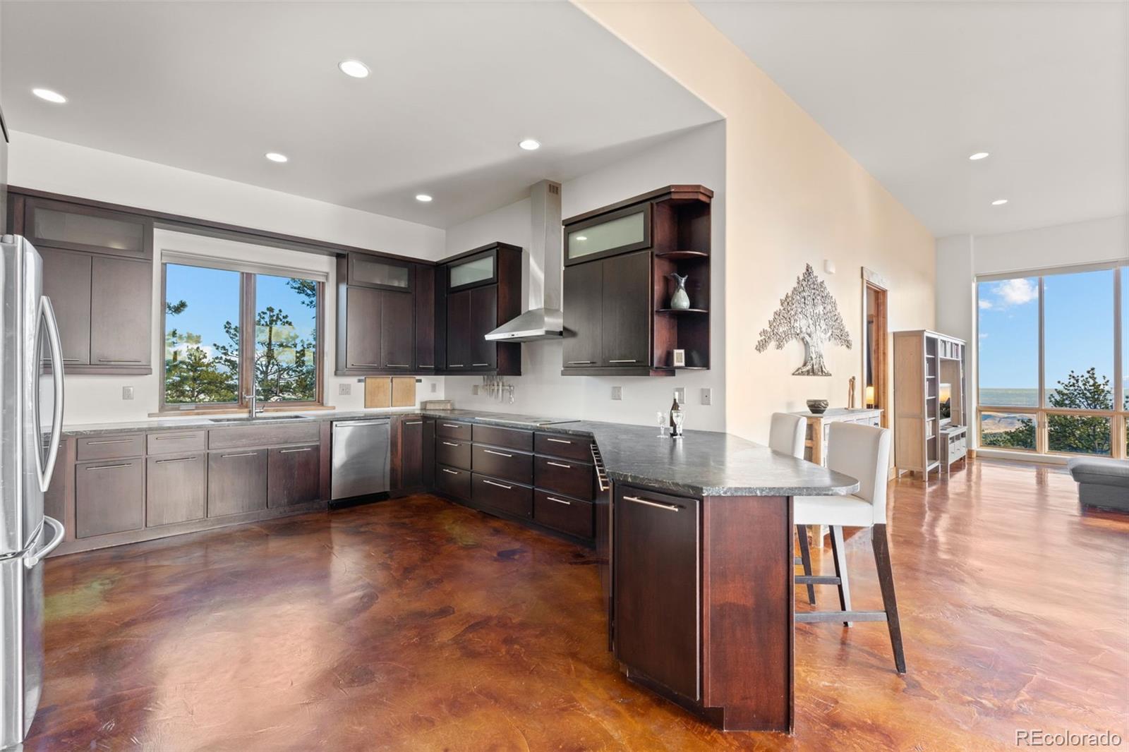 27659 Misty Road Golden, CO 80403 - Photo 17 of 50 a kitchen with stainless steel appliances kitchen island granite countertop a stove a sink a microwave a dining table and chairs
