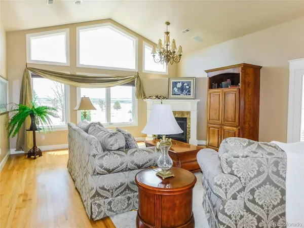 a living room with furniture a chandelier and a large window