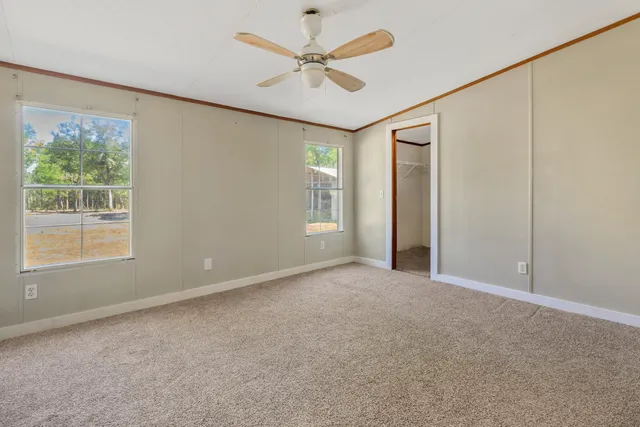 a view of an empty room with wooden floor and closet