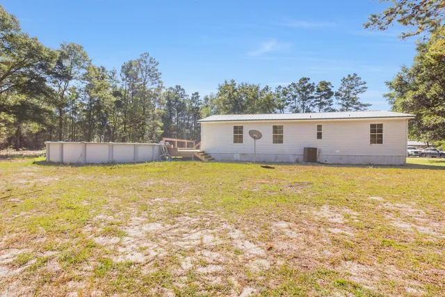 an aerial view of a house with a yard and lake