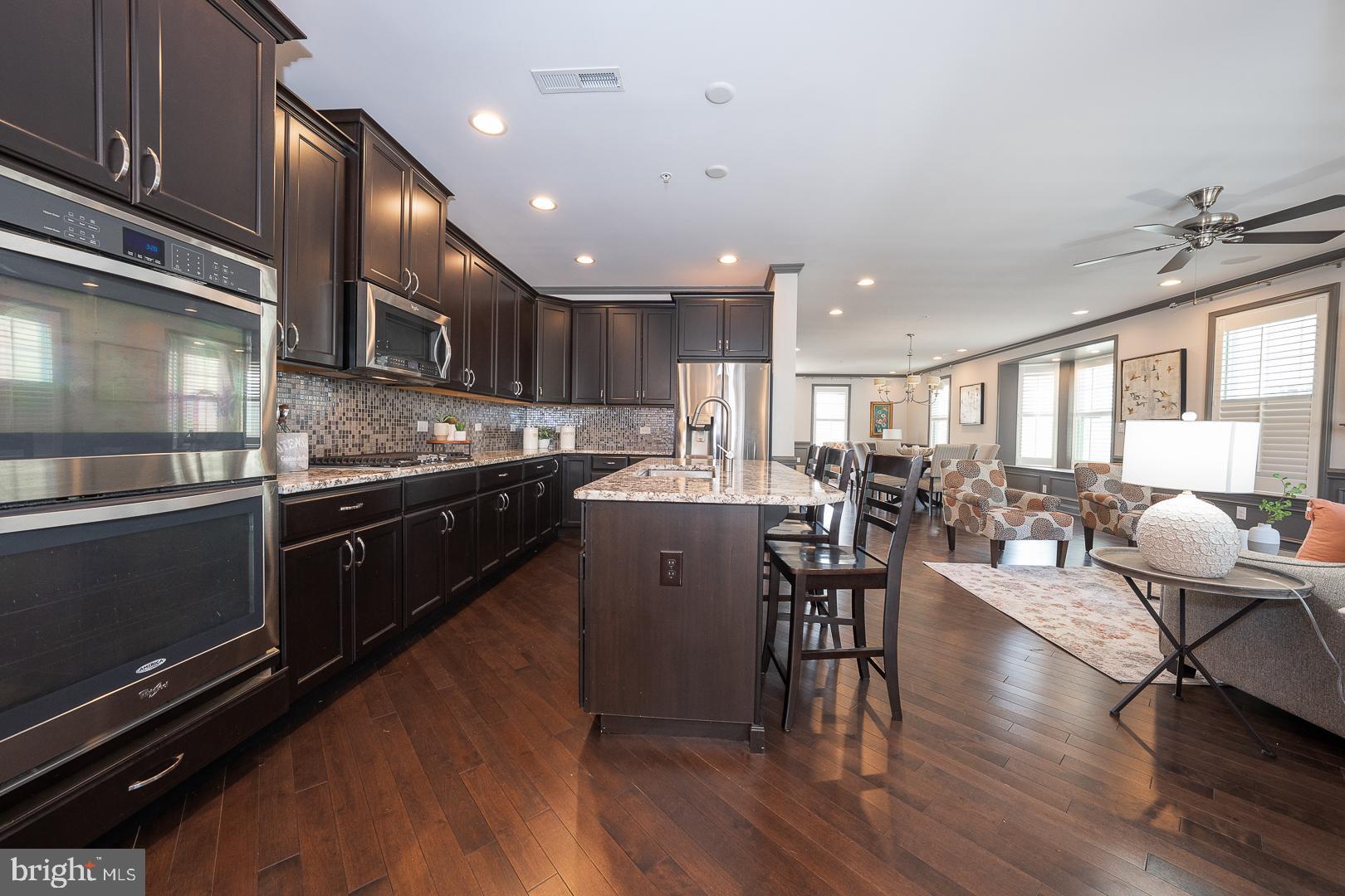 131 Spring Oak Drive Malvern, PA 19355 - Photo 18 of 93 a kitchen with stainless steel appliances granite countertop a stove top oven a sink a dining table and chairs with wooden floor