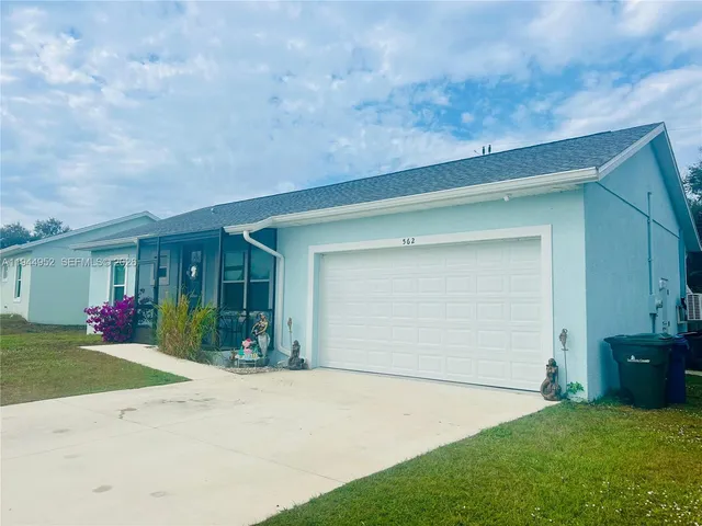 front view of a house with a yard and garage