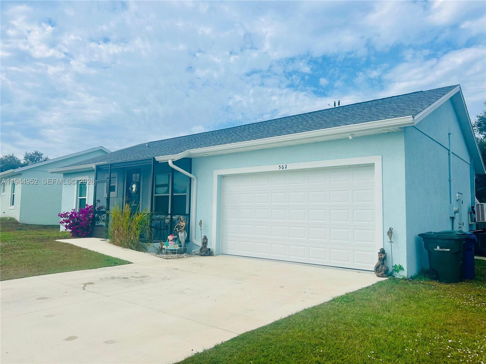 front view of a house with a yard and garage