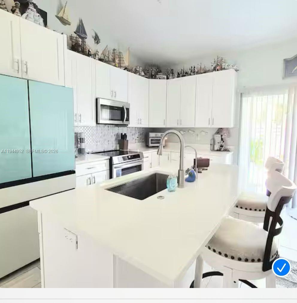 562 Flamingo Road Venice, FL 34293 - Photo 4 of 15 a kitchen with a sink a stove and cabinets