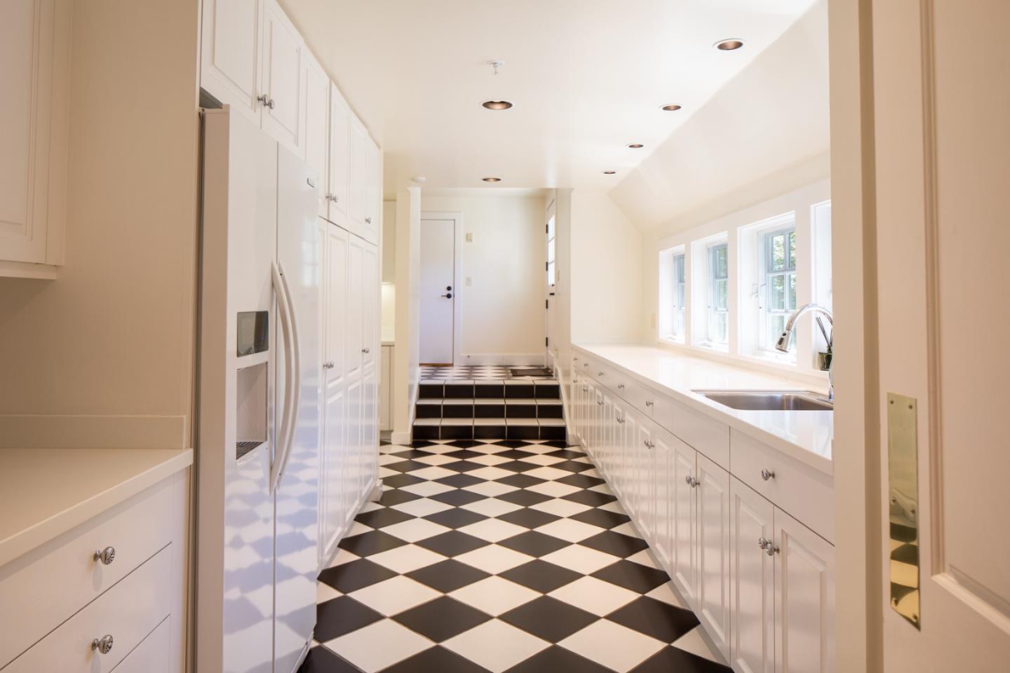 5445 Quail Way Carmel, CA 93923 - Photo 25 of 28 a large white kitchen with a large mirror and a sink
