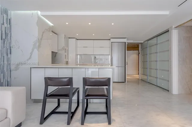 a dining room with furniture and kitchen view