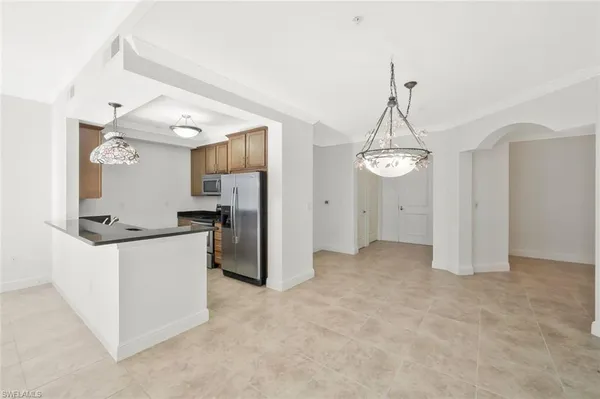 a view of a kitchen with refrigerator and cabinets