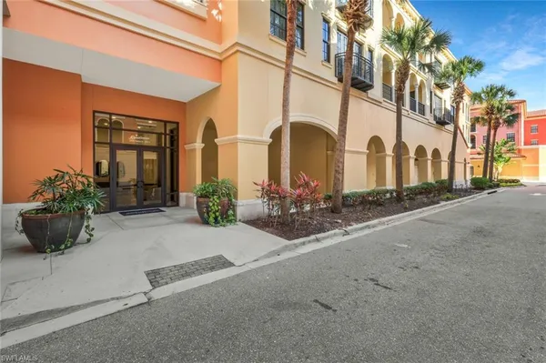 a view of a blue house with potted plants and a bench