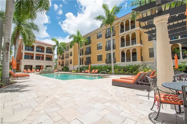 a view of a building with backyard garden and sitting area
