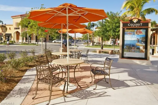 a patio with a table and chairs under an umbrella