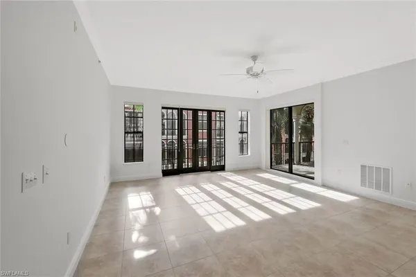 a view of an empty room with a window and a kitchen