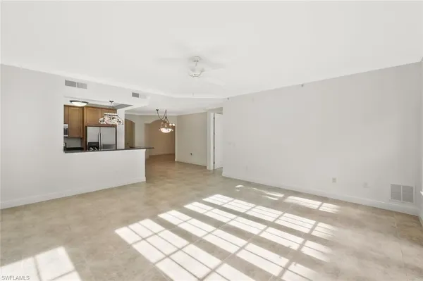 a view of a big room with wooden floor and windows