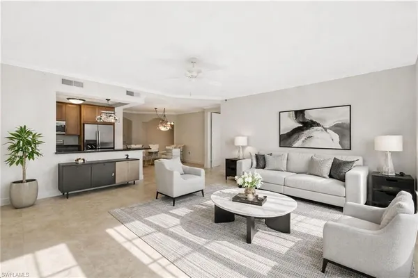 a living room with furniture and view of kitchen