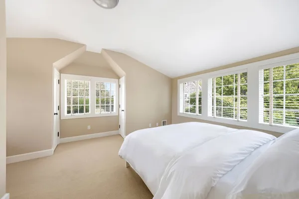 a large bed sitting in a bedroom next to a window