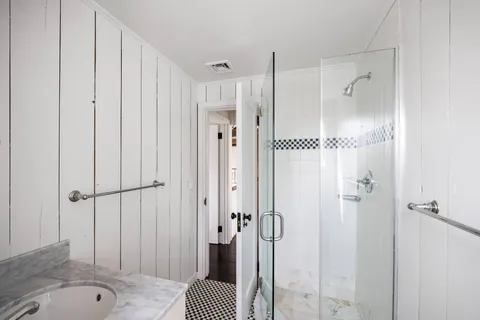 a bathroom with a tub shower and sink