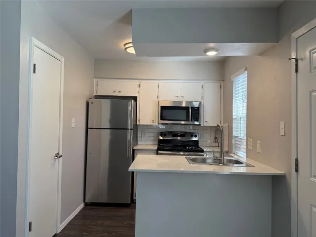 a kitchen with stainless steel appliances a refrigerator and a stove top oven