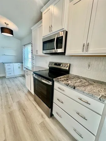 a kitchen with stainless steel appliances granite countertop a stove a microwave and a sink