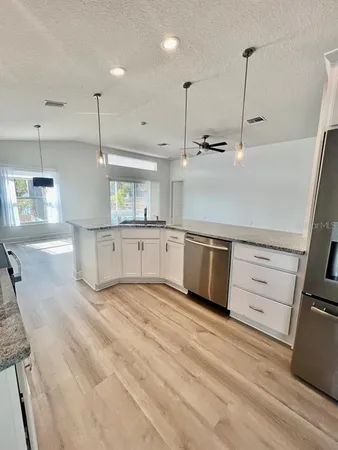 a kitchen with stainless steel appliances granite countertop a sink a stove and a refrigerator