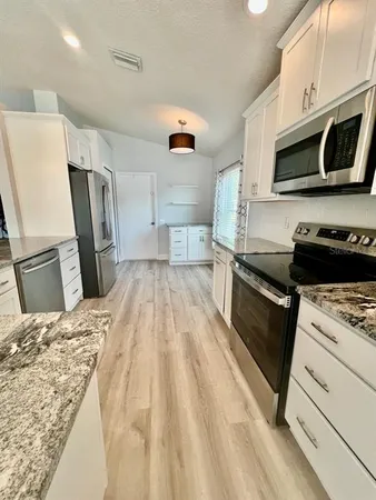 a kitchen with a sink a microwave a stove and refrigerator