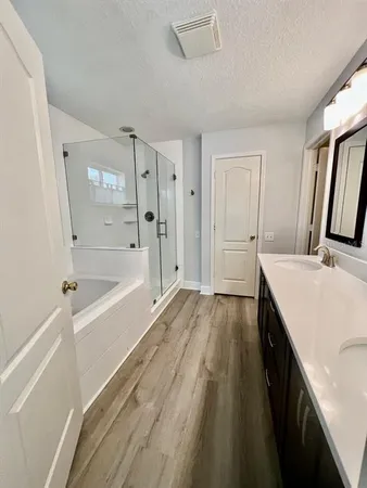 a spacious bathroom with a tub sink and mirror