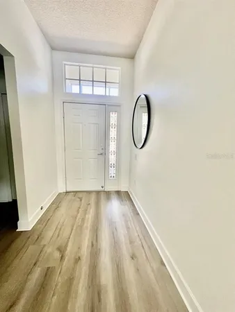 a view of a room with wooden floor and white walls