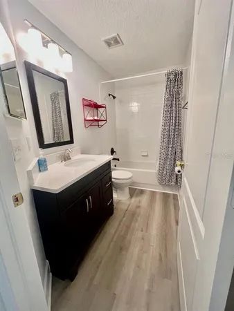 a bathroom with a sink vanity mirror and tub