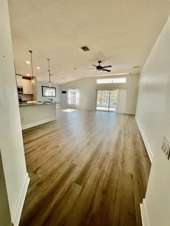 a view of empty room with wooden floor